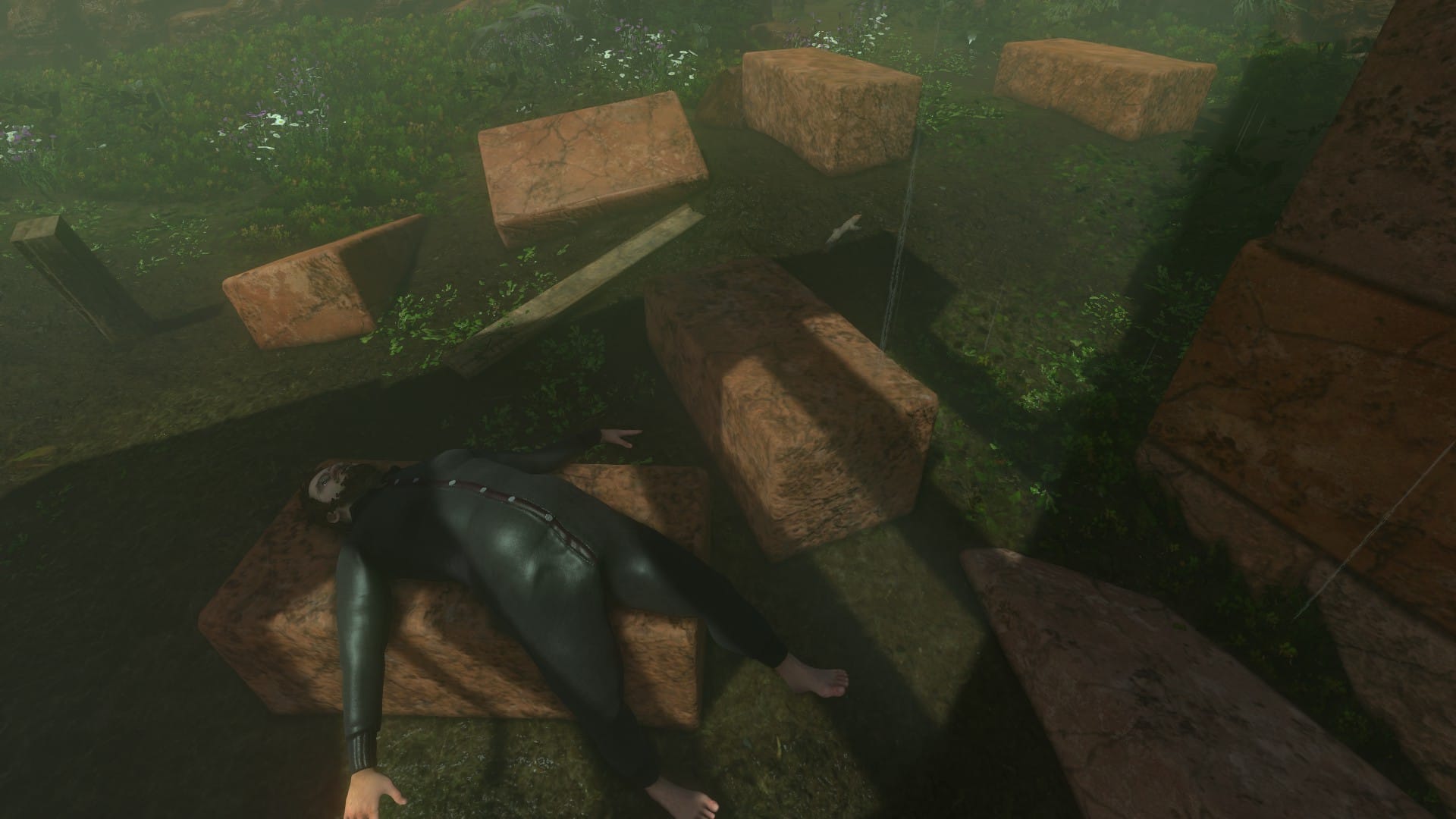 Nate lying limp across a block of red granite.